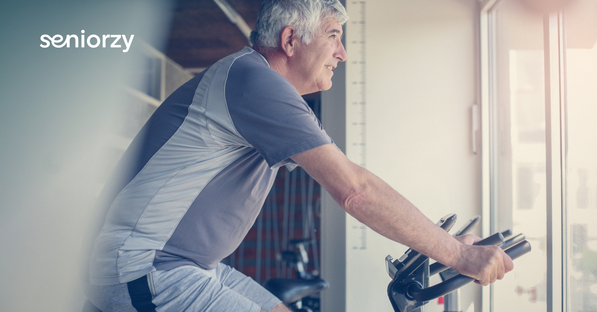 Senior i rower stacjonarny. Codzienna aktywność we własnym salonie